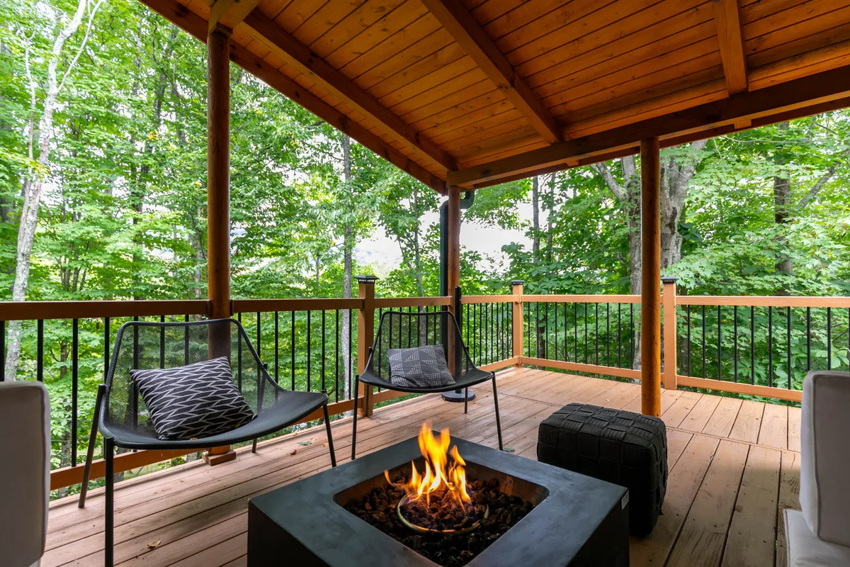 This inviting scene centers on a fire pit with lively flames, surrounded by comfortable seating and lush greenery. It's an ideal spot for evening gatherings, storytelling, and enjoying the warmth and glow against the cool mountain air.